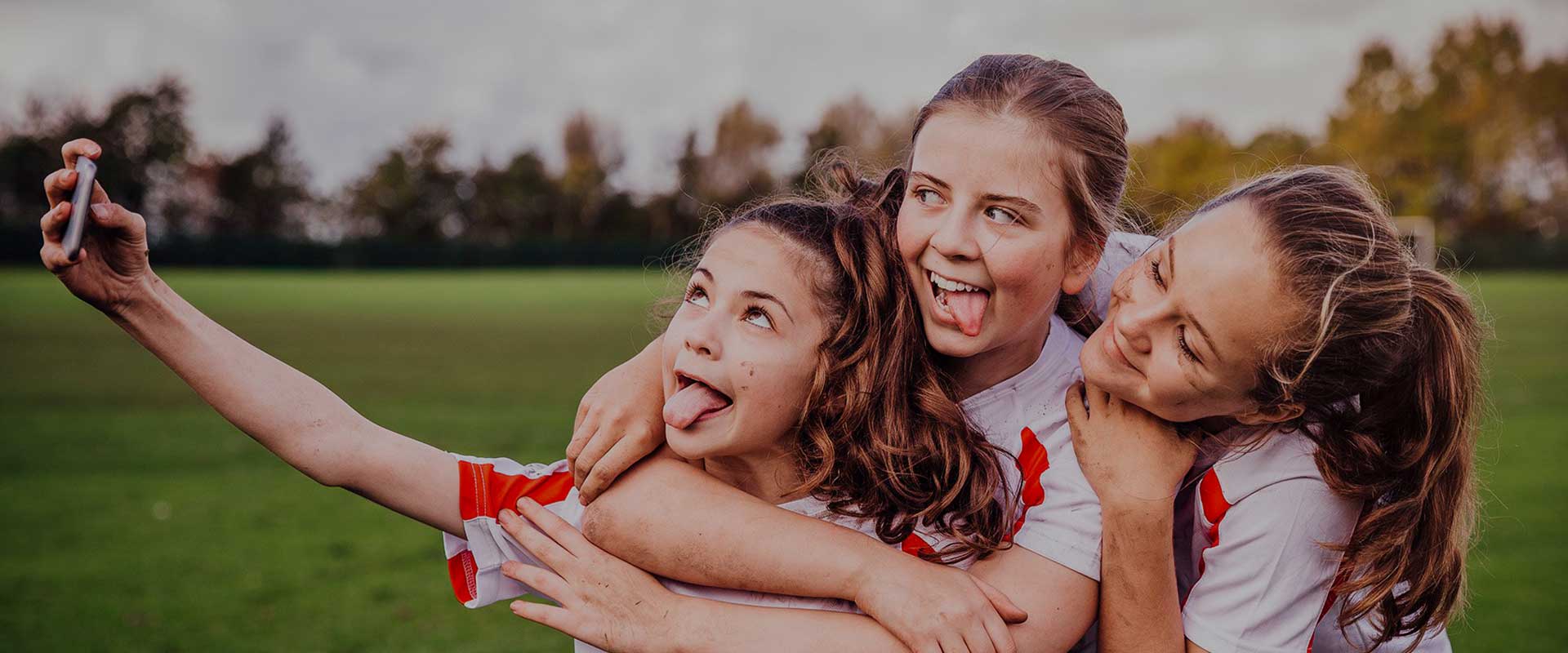 site blog api - three young girls taking a selfie after a game of fotball
